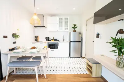 a white kitchen with a table and a refrigerator at Paradise Bird in Nai Yang Beach