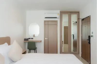 a bedroom with a bed and a desk with a chair at Sunnyside Kata in Kata Beach