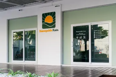a building with three windows and a sign on it at Sunnyside Kata in Kata Beach