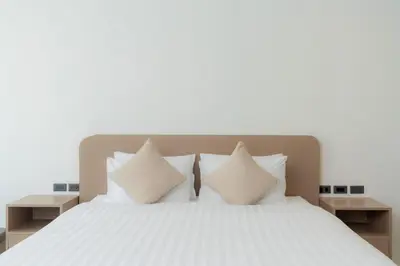 a bedroom with a white bed with white pillows at Sunnyside Kata in Kata Beach