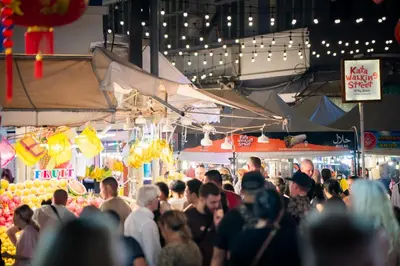 a crowd of people in a market at night at Sunnyside Kata in Kata Beach