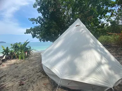 a white umbrella sitting on a beach near the ocean at Private Beach Camping on island at Koh Lon Island in Ko Lon