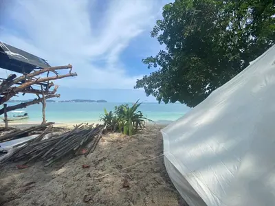 a tent on the beach with the ocean in the background at Private Beach Camping on island at Koh Lon Island in Ko Lon