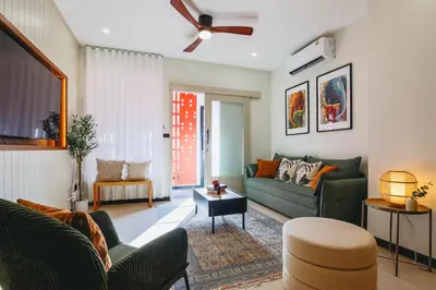 a living room with a green couch and a table at Sea Breeze Villa Patong in Patong Beach