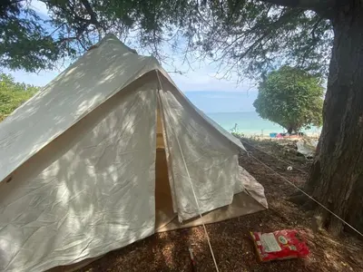 a tent sitting under a tree next to the beach at Naturist Beach Camping Private Beach Phuket in Ko Lone