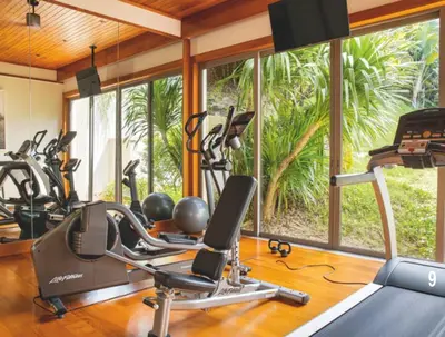 a gym with several treadmills and exercise bikes at Villa 7 Miramare Andara Signature - The Most Exclusive Villa in Phuket in Amphoe Thalang