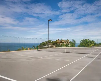 a tennis court with a tennis net on the ocean at Villa 7 Miramare Andara Signature - The Most Exclusive Villa in Phuket in Amphoe Thalang