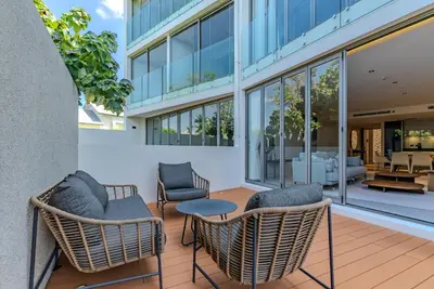 a patio with chairs and tables and a building at Bluepoint by Villacarte in Patong Beach