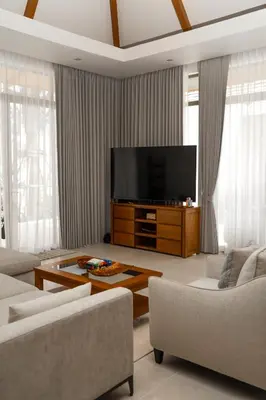 a living room with a flat screen tv on a table at Bang Tao Anchan Flora 3 bd in Ban Phru Champa
