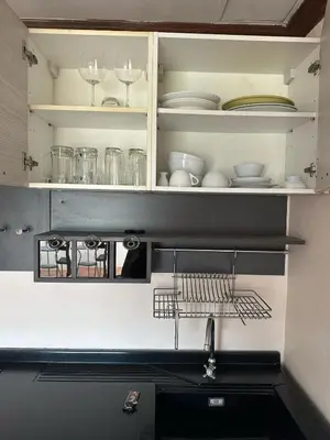 a kitchen with white plates and glasses on shelves at Taj Palace Patong Beach in Patong Beach