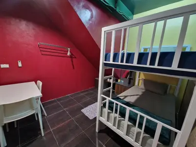 a bunk bed in a room with a red wall at Bonanza Patong Beach II Red Room in Patong Beach