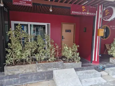 a red building with plants in front of it at Bonanza Patong Beach II Red Room in Patong Beach