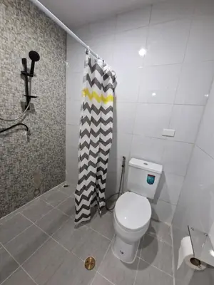 a bathroom with a toilet and a shower curtain at Bonanza Patong Beach II Red Room in Patong Beach