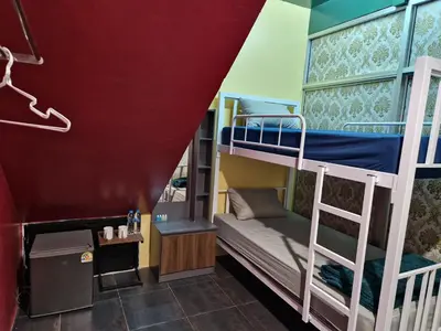 a room with bunk beds and a red wall at Bonanza Patong Beach II Red Room in Patong Beach