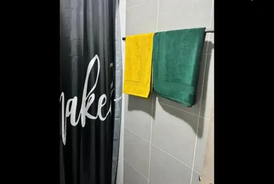 a bathroom with two towels hanging on a wall at Lux Center Apartment in Kathu