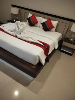 two beds in a hotel room with towels on them at Sumer guesthouses in Patong Beach