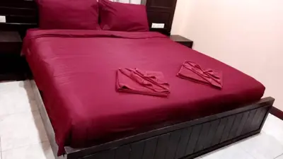 a large bed with pink sheets and shoes on it at Sumer guesthouses in Patong Beach