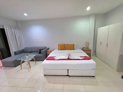 a bedroom with a large bed and a couch at Sunshine Guesthouse Nanai Patong in Patong Beach