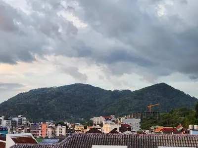 a view of a city with a mountain in the background at Sunshine Guesthouse Nanai Patong in Patong Beach