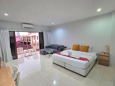 a bedroom with a bed and a living room at Sunshine Guesthouse Nanai Patong in Patong Beach