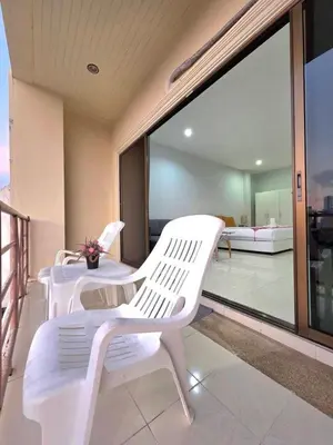 two white chairs sitting on the balcony of a building at Sunshine Guesthouse Nanai Patong in Patong Beach
