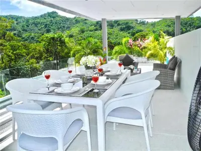 a white dining table and chairs on a balcony at Skylight Nice Pool Villa in Kamala in Kamala Beach