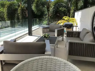 a patio with couches and a tennis court at Skylight Nice Pool Villa in Kamala in Kamala Beach