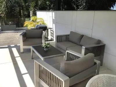 a patio with chairs and couches and a table at Skylight Nice Pool Villa in Kamala in Kamala Beach