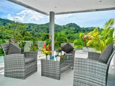 a patio with wicker chairs and a glass table at Skylight Nice Pool Villa in Kamala in Kamala Beach