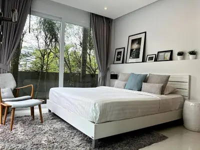 a bedroom with a bed and a chair and a window at Skylight Nice Pool Villa in Kamala in Kamala Beach