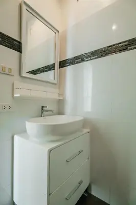 a white bathroom with a sink and a mirror at Skyfall Private Pool Villa In Rawai in Rawai Beach