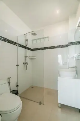 a white bathroom with a toilet and a sink at Skyfall Private Pool Villa In Rawai in Rawai Beach