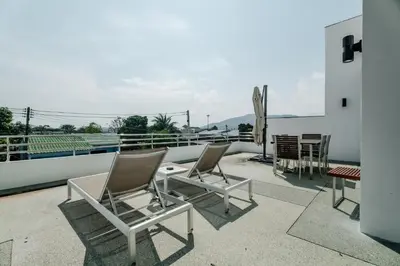 a patio with chairs and a table on a roof at Skyfall Private Pool Villa In Rawai in Rawai Beach