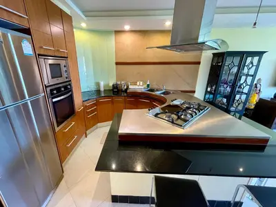 a kitchen with a stainless steel refrigerator and a stove at Kata Seaview Serenity - Luxury 1BR Apartment in Karon Beach
