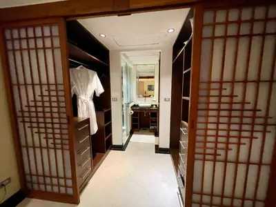 a walk in closet with a mirror and a sink at Kata Seaview Serenity - Luxury 1BR Apartment in Karon Beach