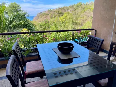 a table with a bowl on it on a balcony at Kata Seaview Serenity - Luxury 1BR Apartment in Karon Beach