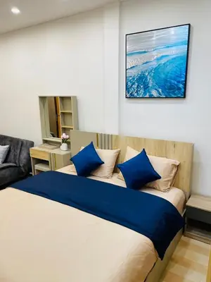 a bedroom with a large bed with blue pillows at Baannira บ้านนิรา in Ban Sam Kong