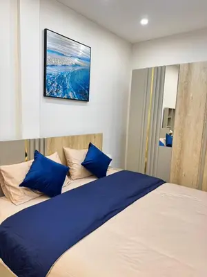 a bedroom with a large bed with blue pillows at Baannira บ้านนิรา in Ban Sam Kong