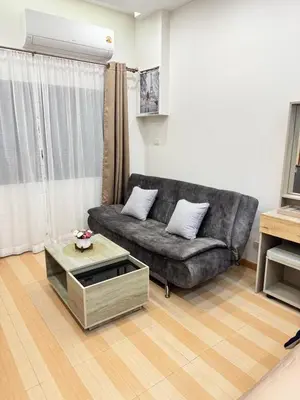 a living room with a couch and a coffee table at Baannira บ้านนิรา in Ban Sam Kong