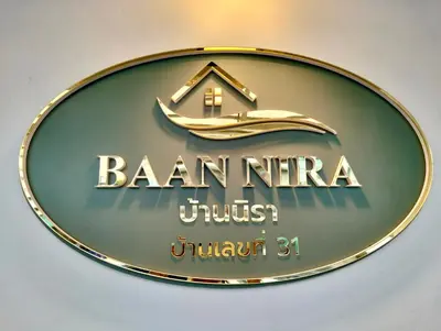 a sign for a hotel with a house on it at Baannira บ้านนิรา in Ban Sam Kong