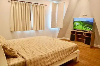 a bedroom with a bed and a flat screen tv at 2 Bedrooms House with Private Pool the heart of rawai in Ban Saiyuan (1)