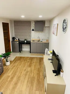 a living room with a kitchen and a desk at Baannira บ้านนิรา in Ban Sam Kong