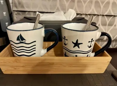 two coffee mugs sitting on a wooden tray at Baannira บ้านนิรา in Ban Sam Kong