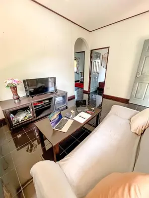 a living room with a couch and a table with a laptop at Sea House in Panwa in Ban Lo Long