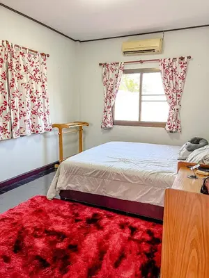 a bedroom with a bed and a window and a red rug at Sea House in Panwa in Ban Lo Long