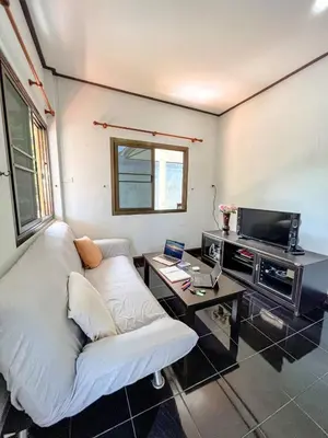 a living room with a white couch and a table at Sea House in Panwa in Ban Lo Long