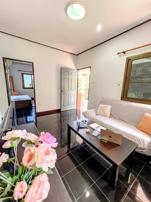 a living room with a couch and a coffee table at Sea House in Panwa in Ban Lo Long