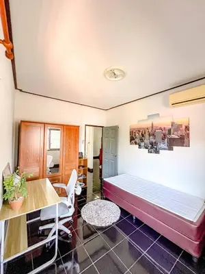 a bedroom with a bed and a table and chairs at Sea House in Panwa in Ban Lo Long