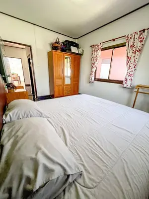 a bedroom with a large white bed and two windows at Sea House in Panwa in Ban Lo Long