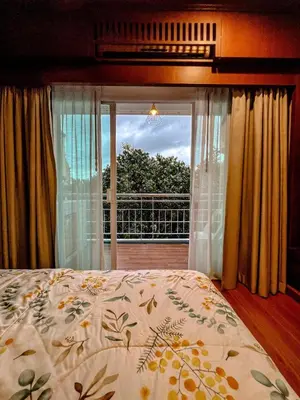 a bedroom with a bed and a view of a balcony at Green Place in Phuket Town